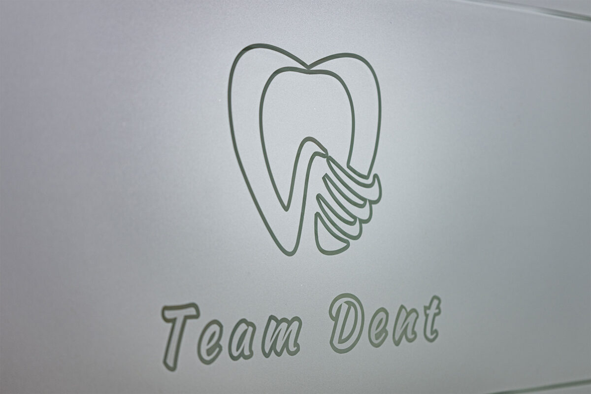 Zahnarzt TEAM DENT Logo an Glaswand
